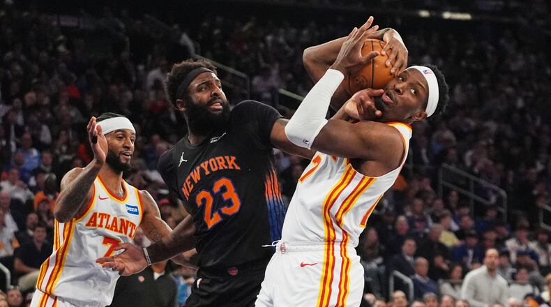 The Hawks' Nickeil Alexander-Walker (right) fights for control of the ball with the Knicks' Mitchell Robinson (center) during Game 5 of the first-round playoff series April 28, 2026, in New York. (Frank Franklin II/AP)