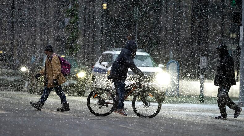 People cross 7th street in the heavy snow on Sunday Dec. 28, 2025 in downtown Minneapolis. (Jerry Holt /Star Tribune via AP)