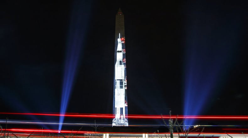 Lights of passing cars streak the foreground as the image of a 363-foot Saturn V rocket is projected on the east face of the Washington Monument in Washington, Tuesday, July 16, 2019, in honor of the 50th anniversary of the Apollo 11 moon landing.