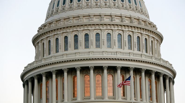 FILE - In this Nov. 18, 2016, file photo. the American flag flies in front of the U.S. Capitol dome at sunset on Capitol Hill in Washington. The end of the 2016 presidential election is at hand. A joint session of Congress is set to count the Electoral College votes on Jan. 6, 2017, a traditional ending to a most unconventional presidential election. (AP Photo/Alex Brandon, file)