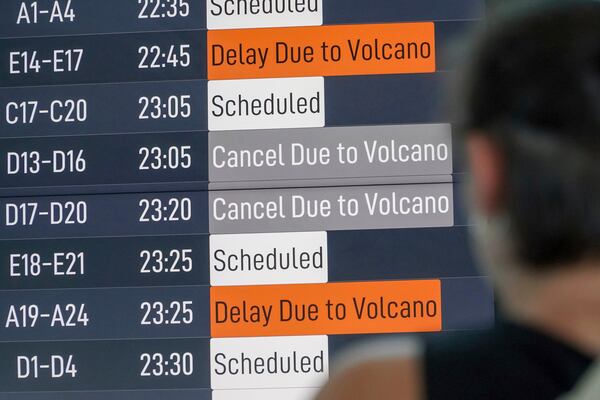 A passenger checks an information board showing disrupted flight schedule due to the eruption of Mount Lewotobi Laki-Laki, at Ngurah Rai International Airport in Badung, Bali, Indonesia, Wednesday, June 18, 2025. (AP Photo/Herdyanto)