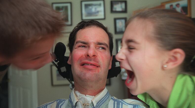 David Jayne, who has had ALS (aka Lou Gehrig's disease) for 12 years, musters his biggest smile after getting kisses on the cheek from children Hunter, 10, (left) and Hannah, 12. (RICH ADDICKS / Staff)