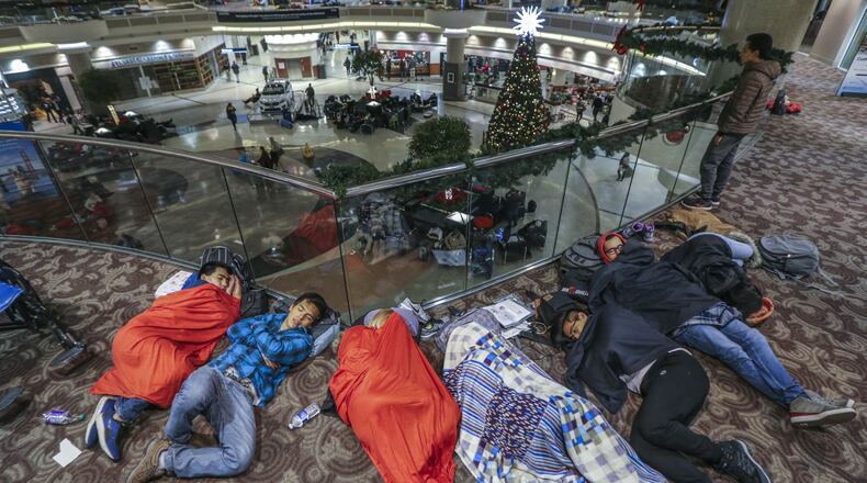 Many stranded travelers slept in the atrium at Hartsfield-Jackson International Airport Sunday night, after a massive power outage forced airlines to cancel more than 1,100 flights and created a logistical nightmare during the already-busy holiday travel season. JOHN SPINK/JSPINK@AJC.COM