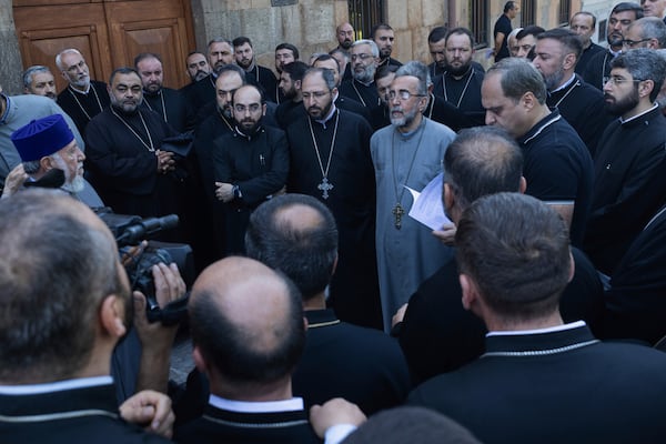 Mikael Ajapahyan, Archbishop of Gyumri and Shirak, center, speaks to other priests as Armenian National Security Service officers arrive to arrest him, at Echmiadzin, the seat of the Armenian Apostolic Church outside Yerevan, Armenia, Friday, June 27, 2025. Catholicos Karekin II is on the left. (Grigor Yepremyan, PAN Photo via AP)
