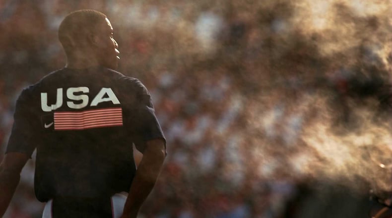 Carl Lewis of the U.S. track and field team walks through a cloud of mist from a mist machine near the long jump pit Monday, July 29, 1996, at the Olympic Stadium during the 1996 Summer Olympic Games in Atlanta. (Hans Deryk/AP)