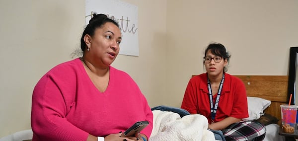 Maria Fernandez and her daughter in the motel room that has been their home for years. They hope for a move to an apartment in April -- with help from a pilot program.