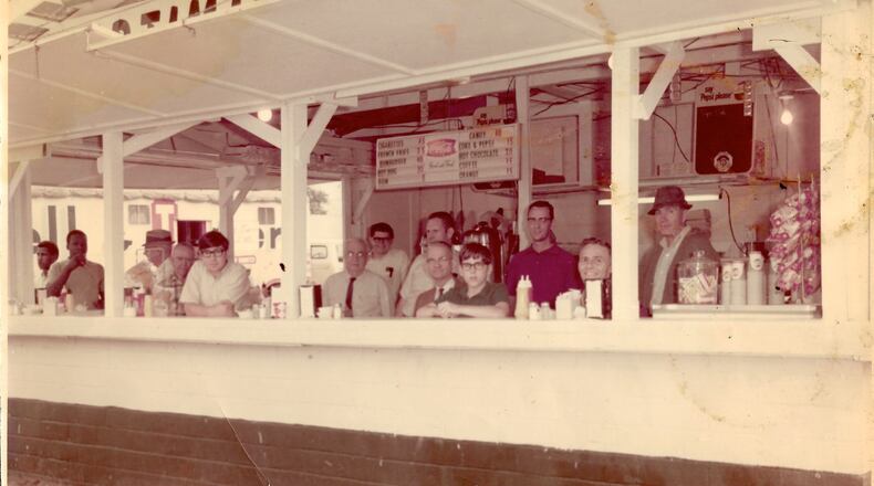 Writer Bill King (at left, leaning on counter), his brother Jonathan (center) and their dad, William D. King (far right), are seen in the Evening Optimist Club fair booth in the late 1960s. (Courtesy of the King family)