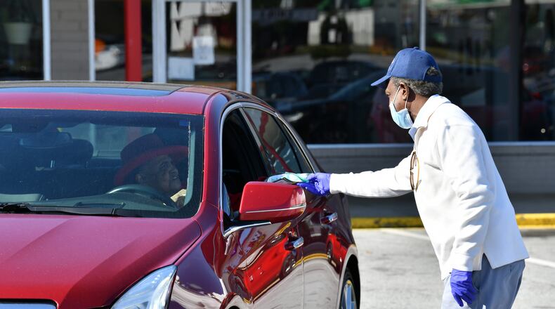 May 9, 2020 Decatur - DeKalb County CEO Michael Thurmond hands a COVID-19 care kit out to Mary Alice Phillips at Big Lots parking lot at 2738 Candler Road in Decatur on Saturday, May 9, 2020. DeKalb County passed out 4,000 COVID-19 care kits containing two non-surgical masks and hand sanitizer to residents May 6, and Saturday, May 9, to mitigate the spread of COVID-19. DeKalb County Board of Health is supporting this initiative. (Hyosub Shin / Hyosub.Shin@ajc.com)
