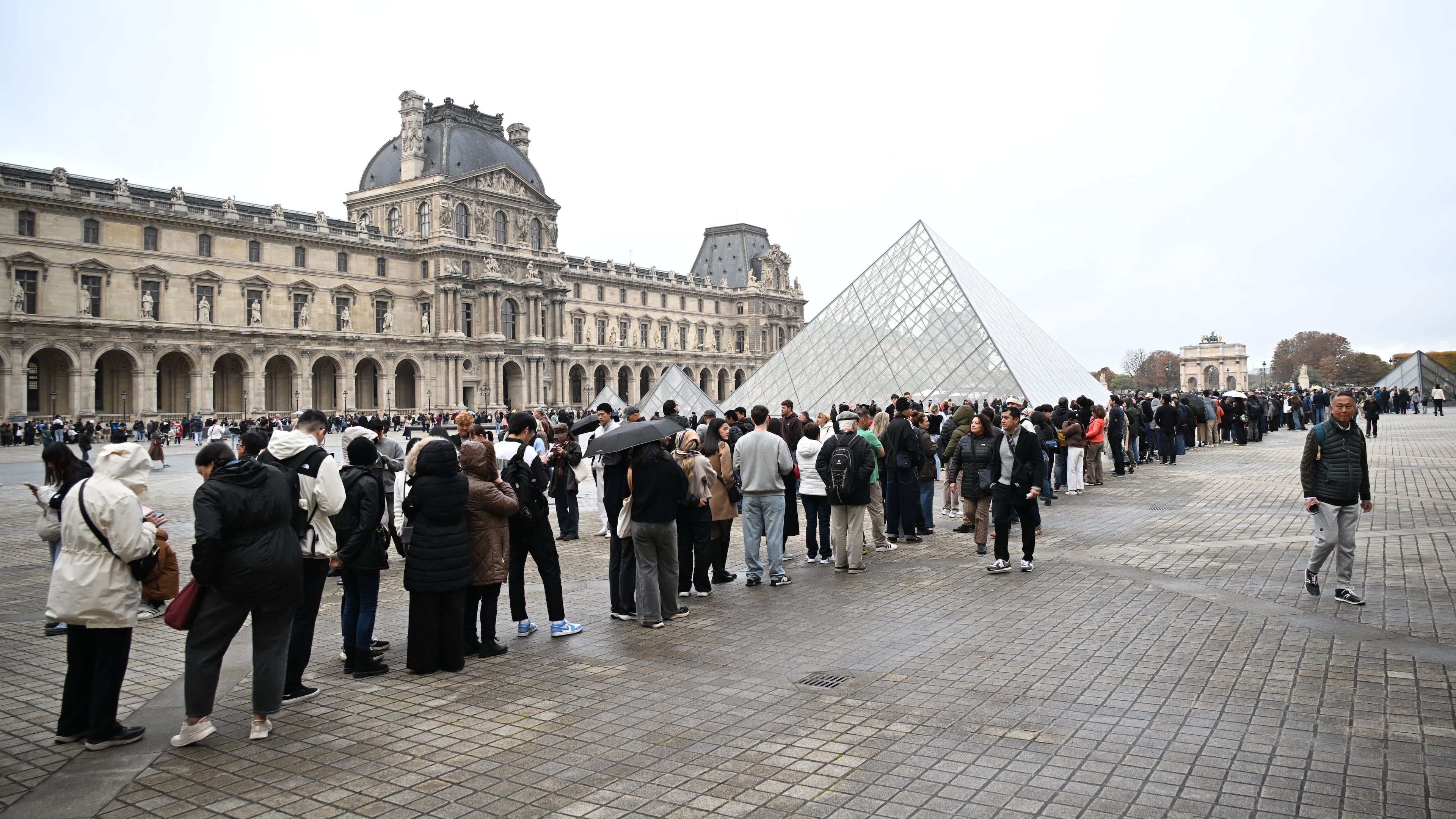 People queue outside the Louvre museum that remains closed for the day after Sunday's jewels robbery, Monday, Oct. 20, 2025 in Paris. (AP Photo/Emma Da Silva)
