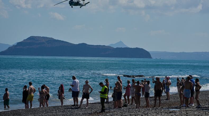 Tourists from nearby hotels watch a military helicopter fly overhead during Medusa 15, a multinational military exercise led by Greece and Egypt, at Maleme on the Greek island of Crete, Friday, Sept. 18, 2026. (AP Photo/Thanassis Stavrakis)
