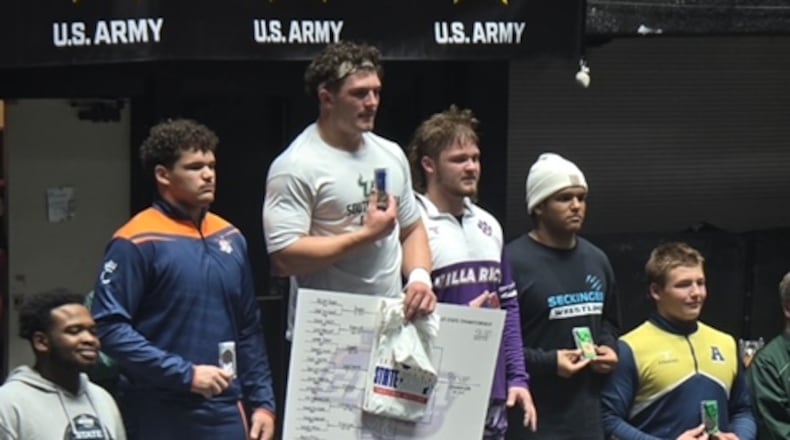 Lee County senior Weston Bryan is highest on the winner's stand after winning the Class 5A title in the 285-pound division. Bryan is also an all-state quarterback committed to Georgia Southern. Go to ajc.com and the AJC News App to see full results from team standings and individual results from the traditional state wrestling meet. (Courtesy)