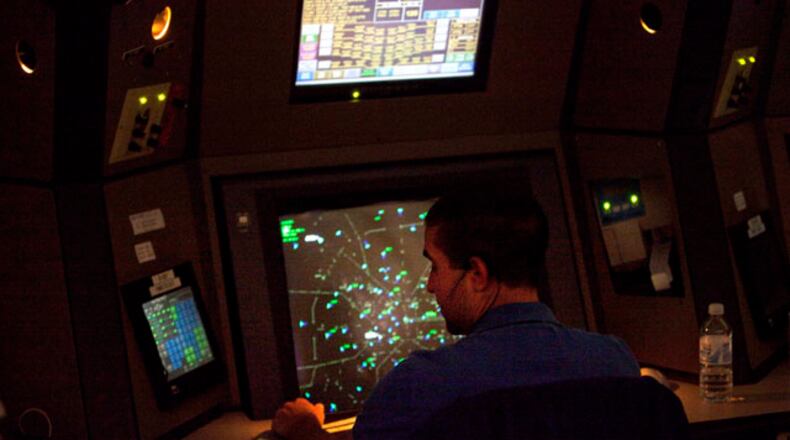 FILE -This April 18, 2011 file photo shows an air traffic controller working in a terminal radar approach control room at the Atlanta TRACON in Peachtree City, Ga. Air traffic controller furloughs scheduled to kick in on Sunday could result in flight delays of more than three hours in Atlanta, as well as significant delays in Chicago, Los Angeles and New York-area airports, federal officials said Thursday. (AP Photo/David Goldman, File-Pool)