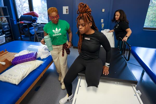 Eboni Kennedy is aided by her mother, Felicia Metcalf, during a recent session. (Jason Getz/AJC)