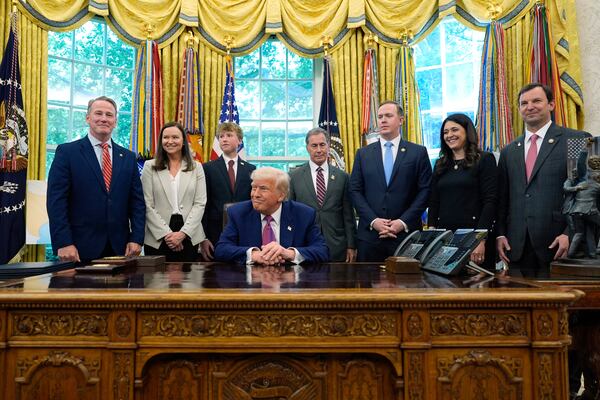 President Donald Trump speaks with reporters at a bill signing event in the White House on Friday. U.S. Rep. Brian Jack, R-Peachtree City, is third from the right.