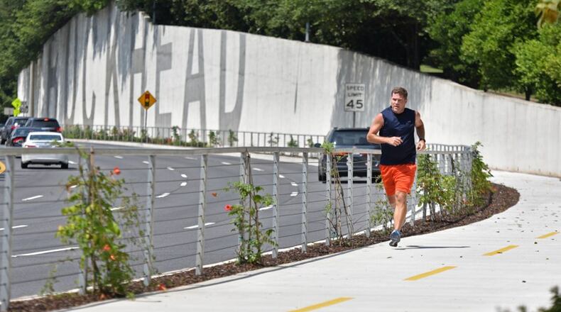 Nick Huston, of Sandy Springs, jogs on the Phase 1 stretch of PATH400 along Ga. 400 in Buckhead. Roswell supports a trail in the Ga. 400 corridor extending south to a possible link-up with PATH400 in Sandy Springs. HYOSUB SHIN / HSHIN@AJC.COM