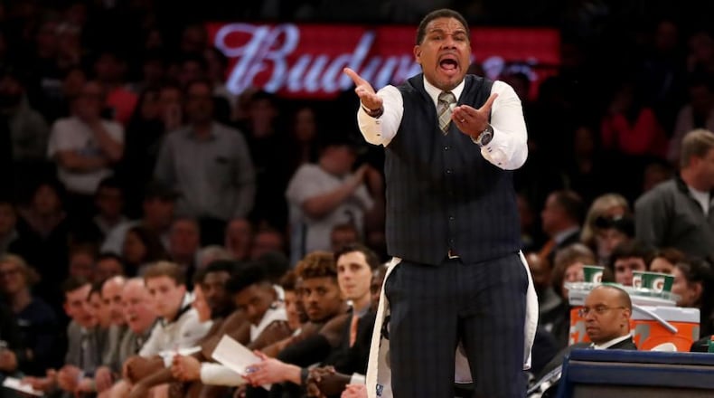 Providence basketball coach Ed Cooley wears a towel as he  shouts instructions to his players during overtime Saturday at the Big East tournament.