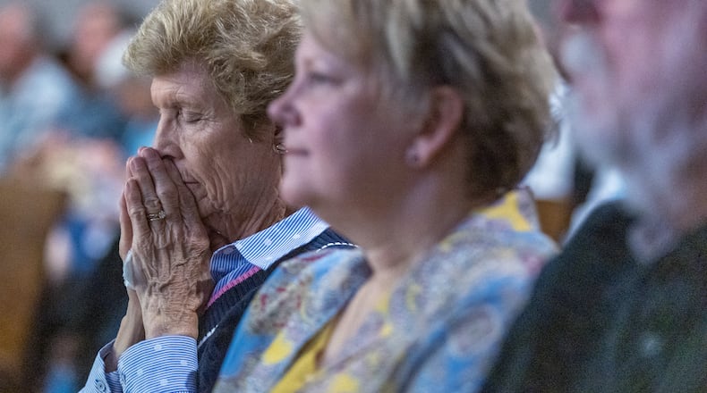 A woman prays in the courtroom at the start of the hearing against the North Ga Conference of the United Methodist Church in Marietta Tuesday, May 16, 2023. (Steve Schaefer/steve.schaefer@ajc.com)