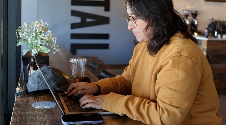 Lauren Contreras, 40, works from her laptop at Foxtail Coffee Co., in Flagstaff, Ariz., on Monday, April 20, 2026. (AP Photo/Cheyanne Mumphrey)