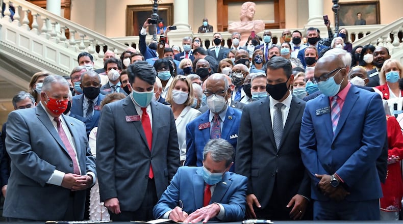 Gov. Brian Kemp signs into law House Bill 426, hate-crimes legislation, on the last day of the legislative session Friday at the Georgia Capitol. (Hyosub Shin / Hyosub.Shin@ajc.com)