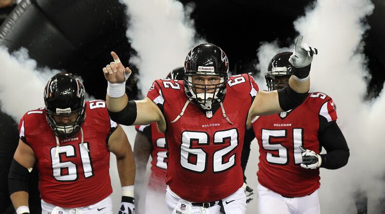 Todd McClure (62) leads the Falcons onto the field in 2012. CURTIS COMPTON / CCOMPTON@AJC.COM