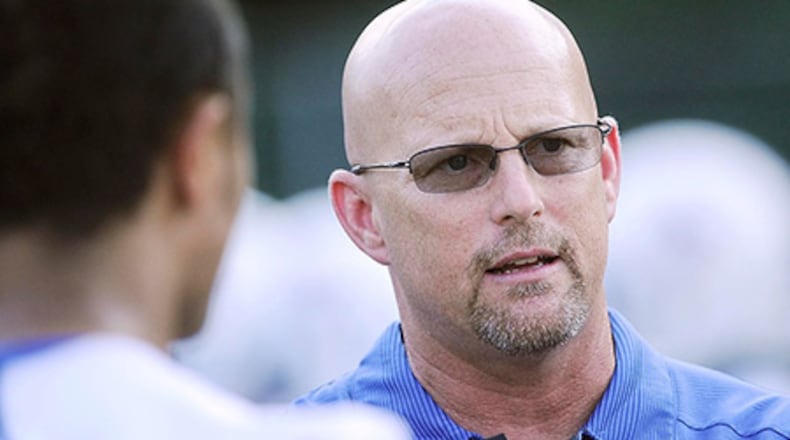 Walton coach Maurice Dixon, right, talks to players before the start of a high school football game against Marietta, Friday Aug. 29, 2014, in Marietta. (Special/John Amis)