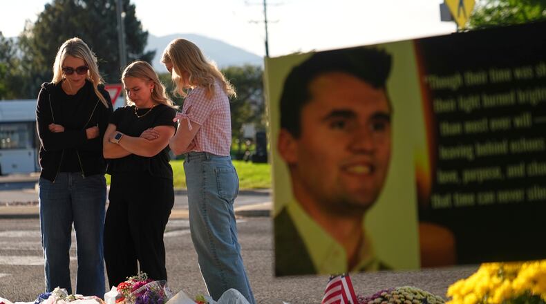 FILE - Women pray at a memorial outside Utah Valley University after Turning Point USA CEO and co-founder Charlie Kirk was shot and killed, Sept. 13, 2025, in Orem, Utah. (AP Photo/Lindsey Wasson, File)