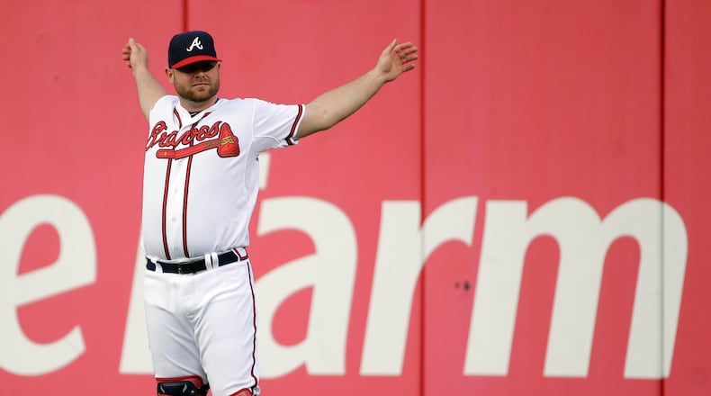 Atlanta Braves catcher Brian McCann stretches in the outfield before the start of a baseball game against the Philadelphia Phillies, Sept. 26, 2013, in Atlanta.