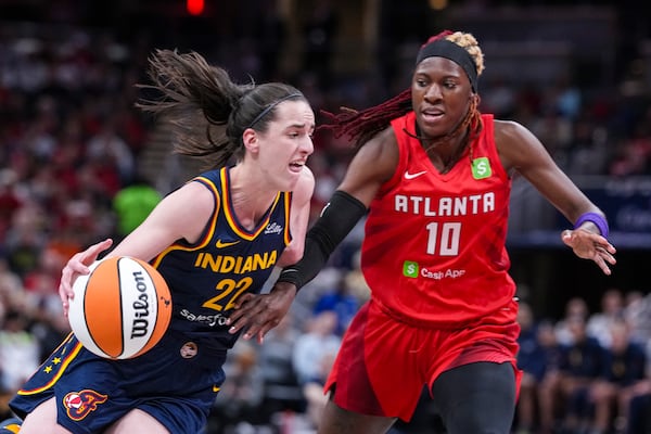 The Fever's Caitlin Clark drives on Dream guard Rhyne Howard during Tuesday's contest in Indianapolis.