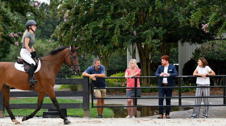 Kyle Hester (left) and his wife Cindy discuss with neighbors Ben Leonard and Christy Hayes (right) as Nicole Stringer (foreground) rides on jumping race horse Leo at Hester’s horse farm home. The Hesters train young horses for competition. (Hyosub Shin / Hyosub.Shin@ajc.com)