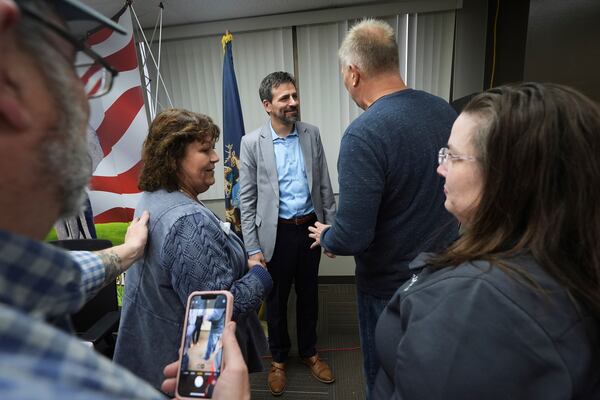 Ryan Kelley, center, speaks with attendees after his talk at the Jackson County Republican headquarters, Thursday, April 10, 2025, in Jackson, Mich. (AP Photo/Paul Sancya)