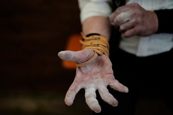 A competitor warms up for his bout while he try to pull the opponent over the table at the German Championships in Fingerhakeln or finger wrestling, in Pang, near Rosenheim, Germany, Sunday, April 27, 2025. (AP Photo/Matthias Schrader)