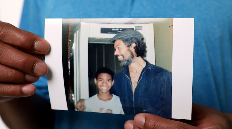 Rumal Rackley, the son of poet and music legend Gil Scott-Heron, holds a photo of him and his father years ago. RYON HORNE / RHORNE@AJC.COM