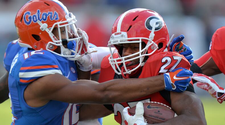 UGA running back Nick Chubb is brought down Gators DB Quincy Wilson during the 2014 Georgia-Florida game. Georgia was ranked in the top 10 and a 12-point favorite against the Gators, but lost 38-20. (Brant Sanderlin/AJC file photo)
