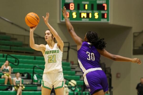 Buford guard Lydia Ledford (21) attempts a shot against Duluth guard Jayla Alexander (30) during the first half of their first-round game of the GHSA Class 7A girls playoffs at the Buford Civic Center on Tuesday, Feb. 21, 2023, in Buford, Ga. (Jason Getz / AJC)