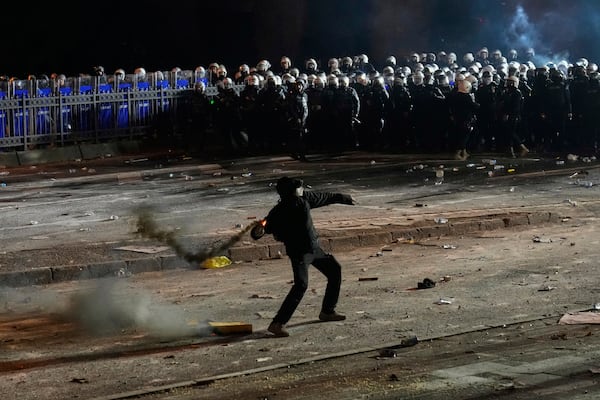 A protester throws a firework during a protest against the arrest of Istanbul's Mayor Ekrem Imamoglu, in Istanbul, Turkey, Saturday, March 22, 2025. (AP Photo/Khalil Hamra)