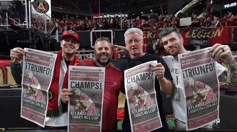 Atlanta United fans hold The Atlanta Journal-Constitution special edition after the team beat the Portland Timbers during MLS championship on Saturday, December 8, 2018, at Merceds-Benz Stadium. (Photo: HYOSUB SHIN / HSHIN@AJC.COM)