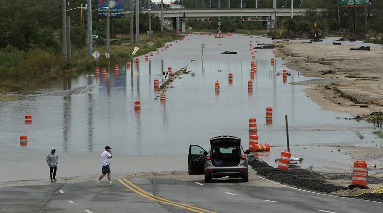 A couple find President Street, which leads to the Islands Expressway to Tybee Island, blocked by flood waters during Hurricane Matthew on Saturday, Oct. 8, 2016, in Savannah. Curtis Compton /ccompton@ajc.com