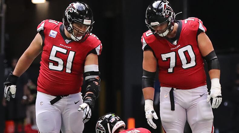 Falcons quarterback Matt Ryan sits on the field with Alex Mack (left) and Jake Matthews (right) looking on after Los Angeles Rams defensive tackle Aaron Donald leveled him causing a fumble that the Rams recovered and knocking Ryan out of the game with an apparent leg injury during the fourth quarter Sunday, Oct. 20, 2019, at Mercedes-Benz Stadium in Atlanta.
