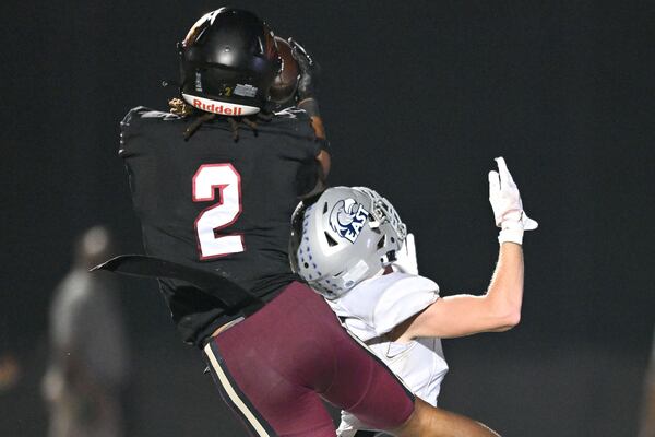 Hebron defensive back Jai'lil Goley (top left) intercepts the ball over East Jackson wide receiver Brady Saunders during the second half of play Friday, Sept. 26, 2025 at Hebron Christian Academy. (Daniel Varnado for the AJC)