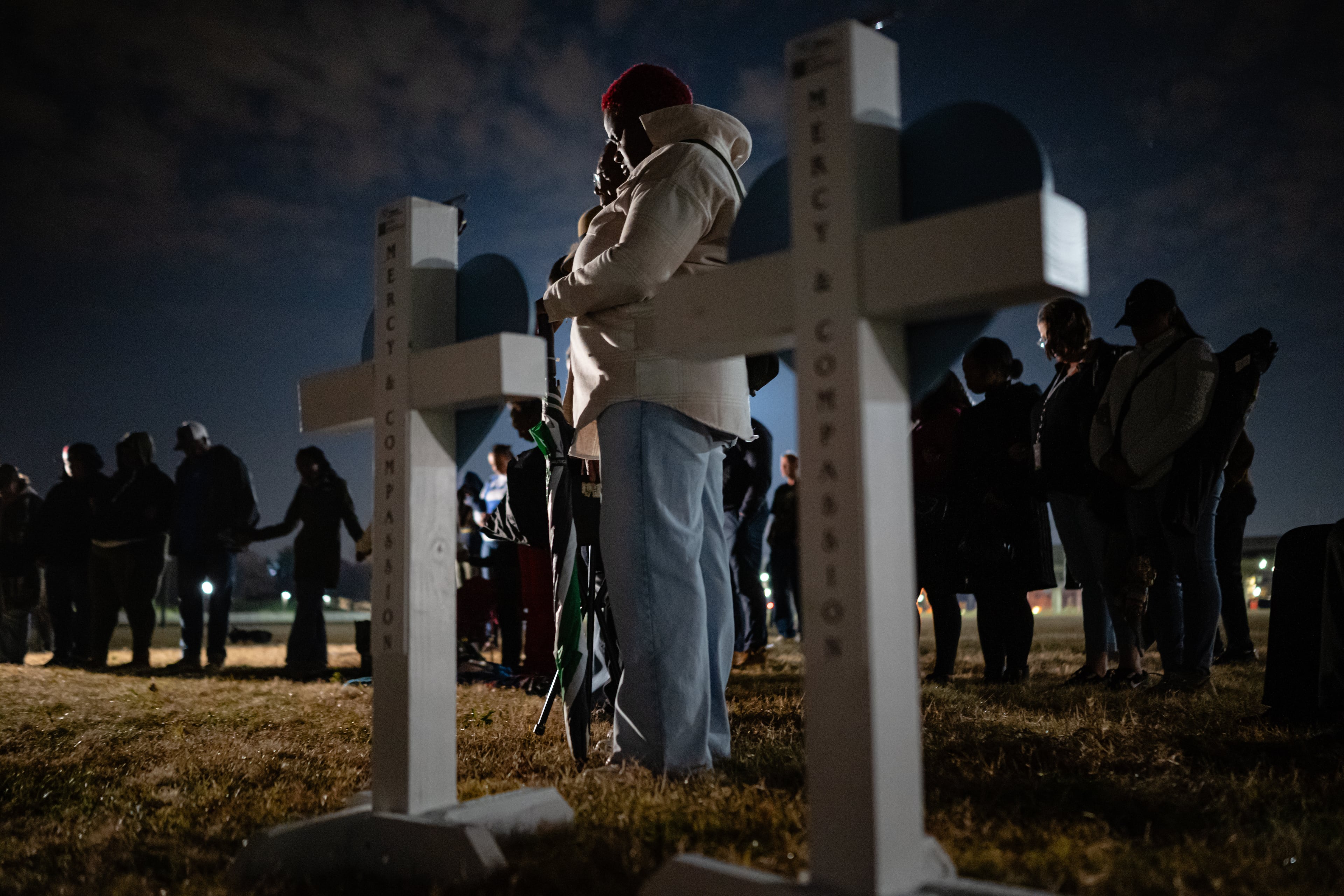 Community members embrace during a vigil at the Great Lawn for those killed and missing after a UPS plane crashed on Friday, Nov. 7, 2025, in Louisville, Ky. (Jon Cherry/AP)