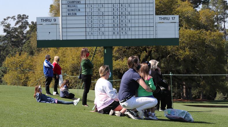 Patrons watch the putting competition on the 18th green by the scoreboard during the putting the Drive, Chip, and Putt Championship at Augusta National Golf Club on Sunday, April 4, 2021, in Augusta. Curtis Compton / Curtis.Compton@ajc.com