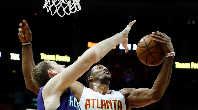 Atlanta Hawks center Dwight Howard (8) battles Charlotte Hornets center Cody Zeller (40) for a rebound in the first half of an NBA basketball game Saturday, Dec. 17, 2016, in Atlanta. (AP Photo/John Bazemore)