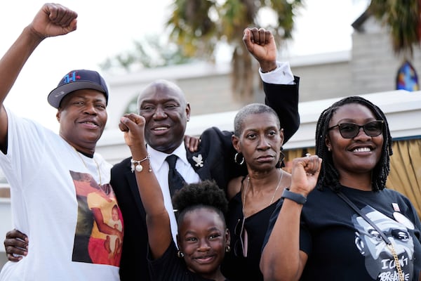 Attorney Ben Crump, second from left, raises his fist with George Floyd's sisters, LeTonya Floyd, left, and Zsa Zsa Floyd, second from left, along with great niece Arianna Williams, 7, and niece Bianca Williams, right, before a memorial service on the anniversary of Floyd's death on Sunday, May 25, 2025, in Houston. (AP Photo/Ashley Landis)