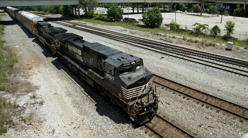 A Norfolk-Southern train travels south close to the Mitchell Street bridge in the Gulch in May 2013. The railroad giant owns land critical to develop the Gulch downtown. The company wants to sell its holdings to developer CIM Group and use proceeds for a potential relocation to Midtown. JASON GETZ / JGETZ@AJC.COM