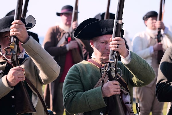 Chris Silver, right, of Celina, Ohio, prepares to face the British during a reenactment in celebration of the 250th anniversary of the Battle of Bunker Hill, Saturday, June 21, 2025, in Gloucester, Mass. (AP Photo/Charles Krupa)