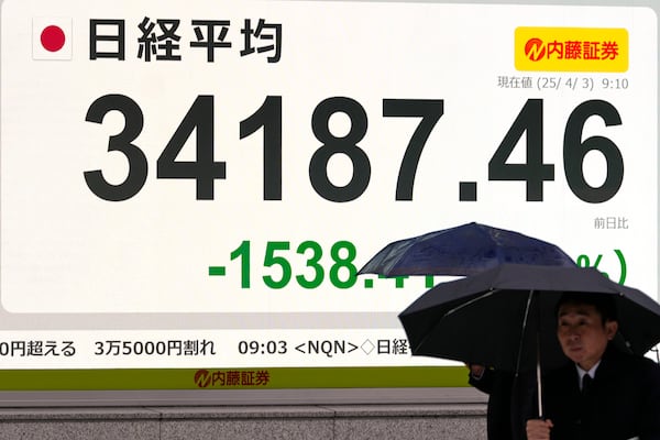 People walk past an electronic stock board showing the day's early loss of Japan's Nikkei 225 index at a securities firm Thursday, April 3, 2025 in Tokyo.(AP Photo/Shuji Kajiyama)
