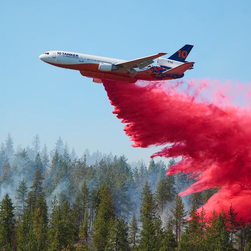 Fire retardant is dropped by air tanker onto the Upriver Fire on Tuesday, June 16, 2026 in Spokane, Wash. (Skyler Geissler via AP)