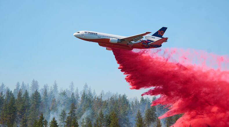 Fire retardant is dropped by air tanker onto the Upriver Fire on Tuesday, June 16, 2026 in Spokane, Wash. (Skyler Geissler via AP)