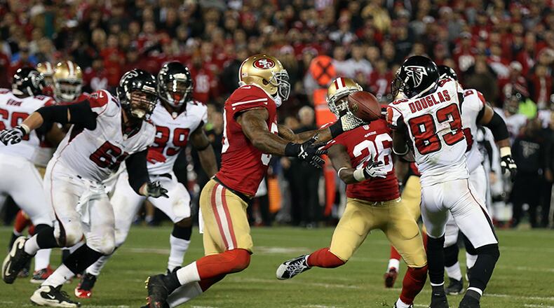 San Francisco 49ers cornerback Tramaine Brock (26) tips the pass intended for Atlanta Falcons wide receiver Harry Douglas (83) into the hands of teammate NaVorro Bowman (53), who ran the interception for a game-clinching 89-yard touchdown, in the closing minutes of the final regular season game at Candlestick Park.