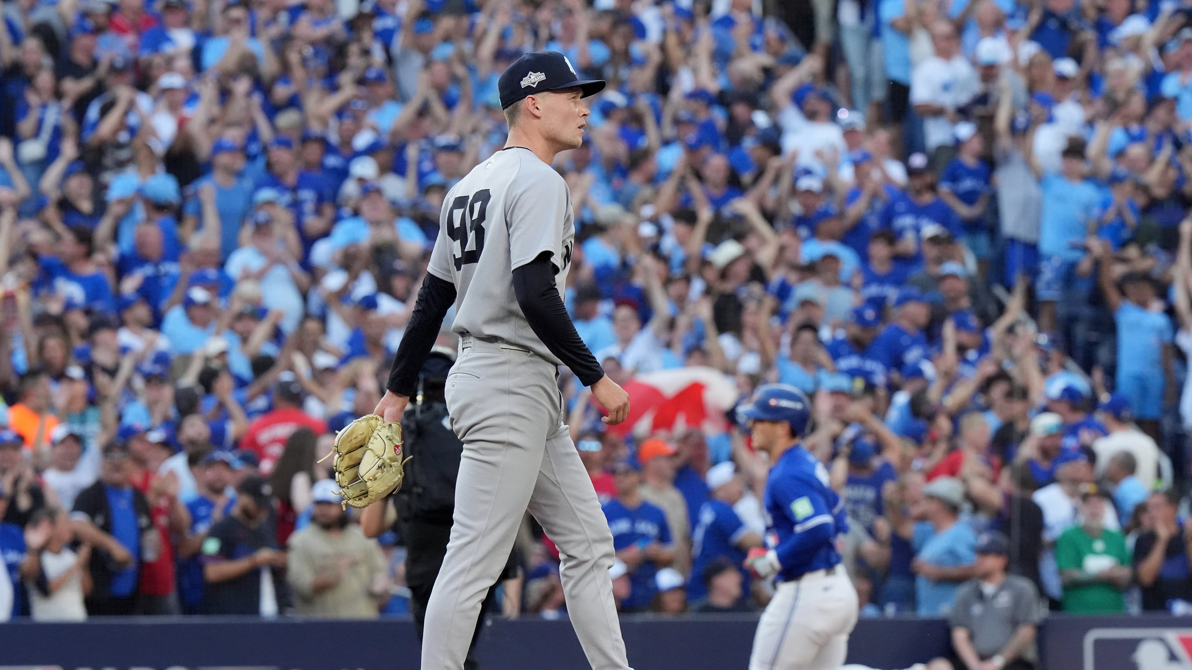 New York Yankees pitcher Will Warren, foreground, reacts as Toronto Blue Jays' Daulton Varsho, back right, rounds the bases after hitting a two-run home run during the fourth inning of Game 2 of baseball's American League Division Series in Toronto, Sunday, Oct. 5, 2025. (Frank Gunn/The Canadian Press via AP)